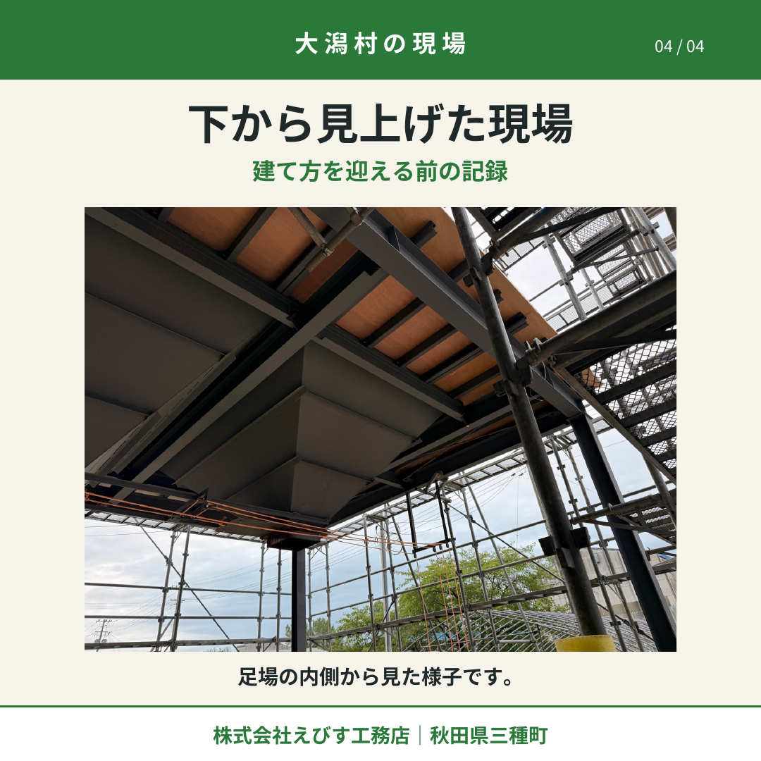 足場の内側から、鋼材と板材を下から見上げた様子。